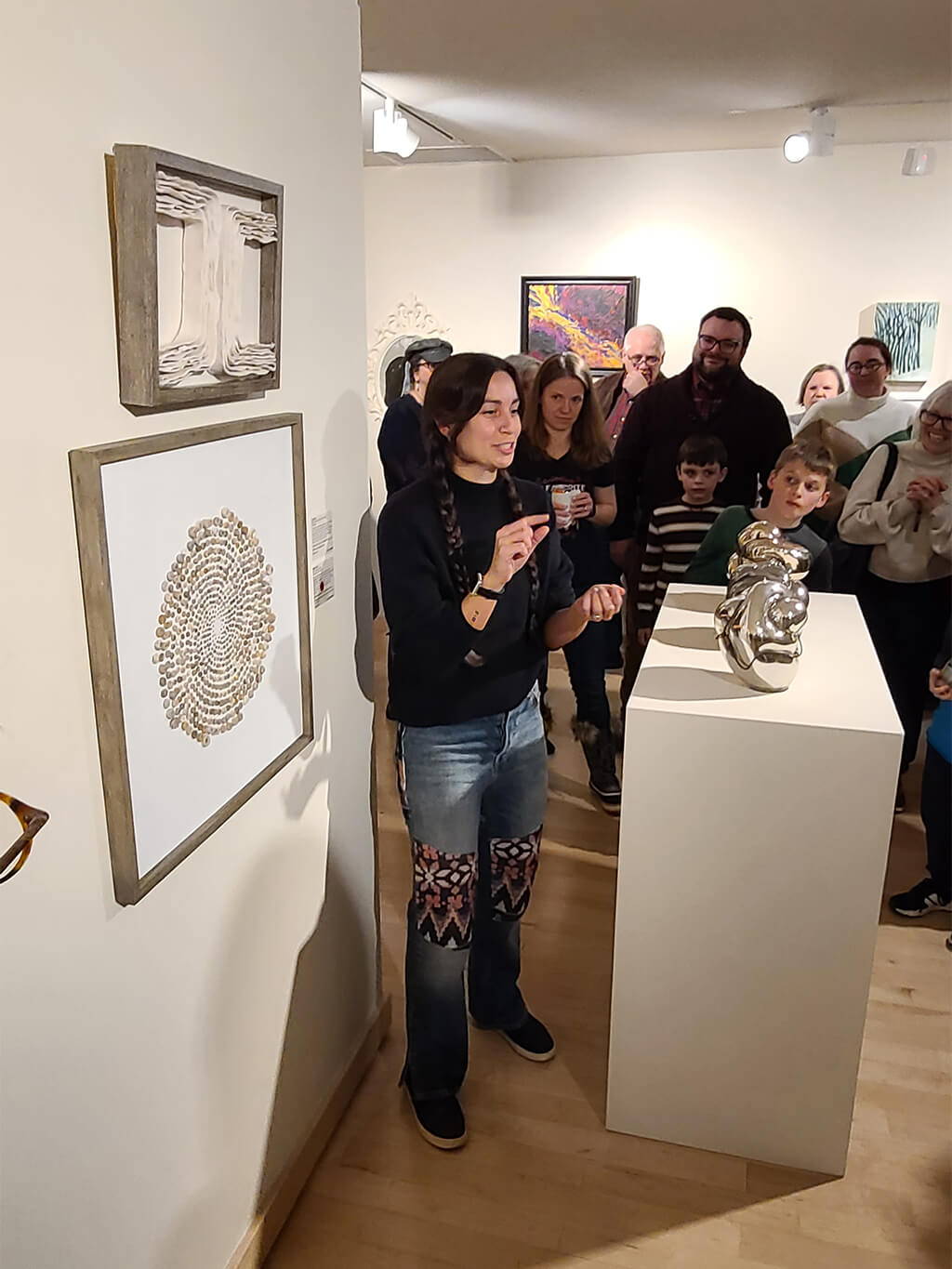 Visitors gathered around artwork in a Krasl gallery